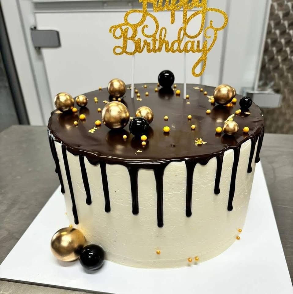 Drip cake con colata di cioccolato e sfere dorate
