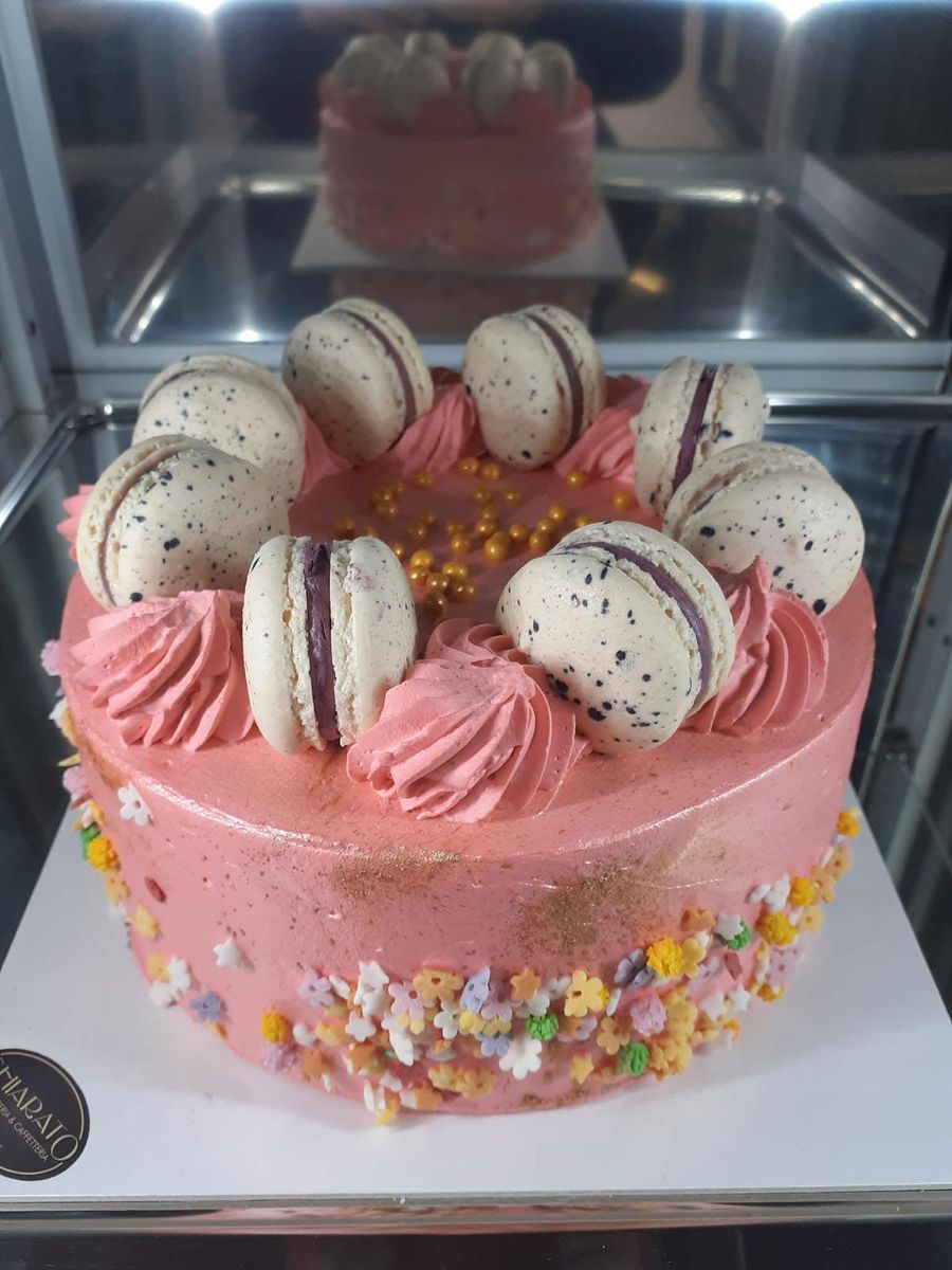 Torta rosa con macaron e ciuffi di crema