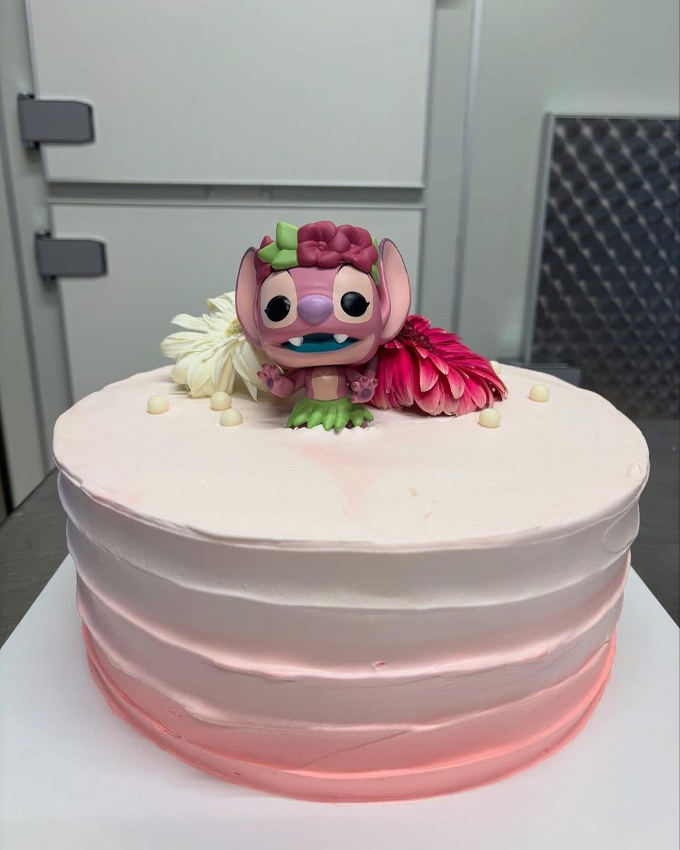Torta a strati rosa con personaggio di zucchero