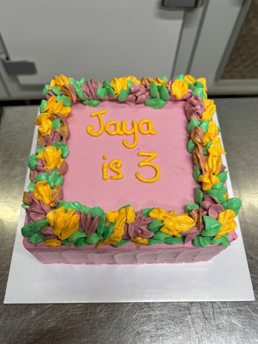 Torta quadrata con fiori di crema e dedica