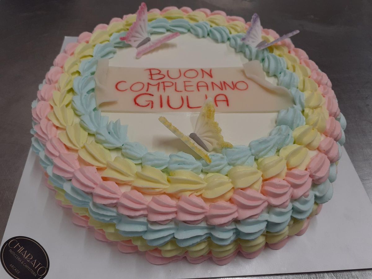 Torta con ciuffi di crema arcobaleno e dedica