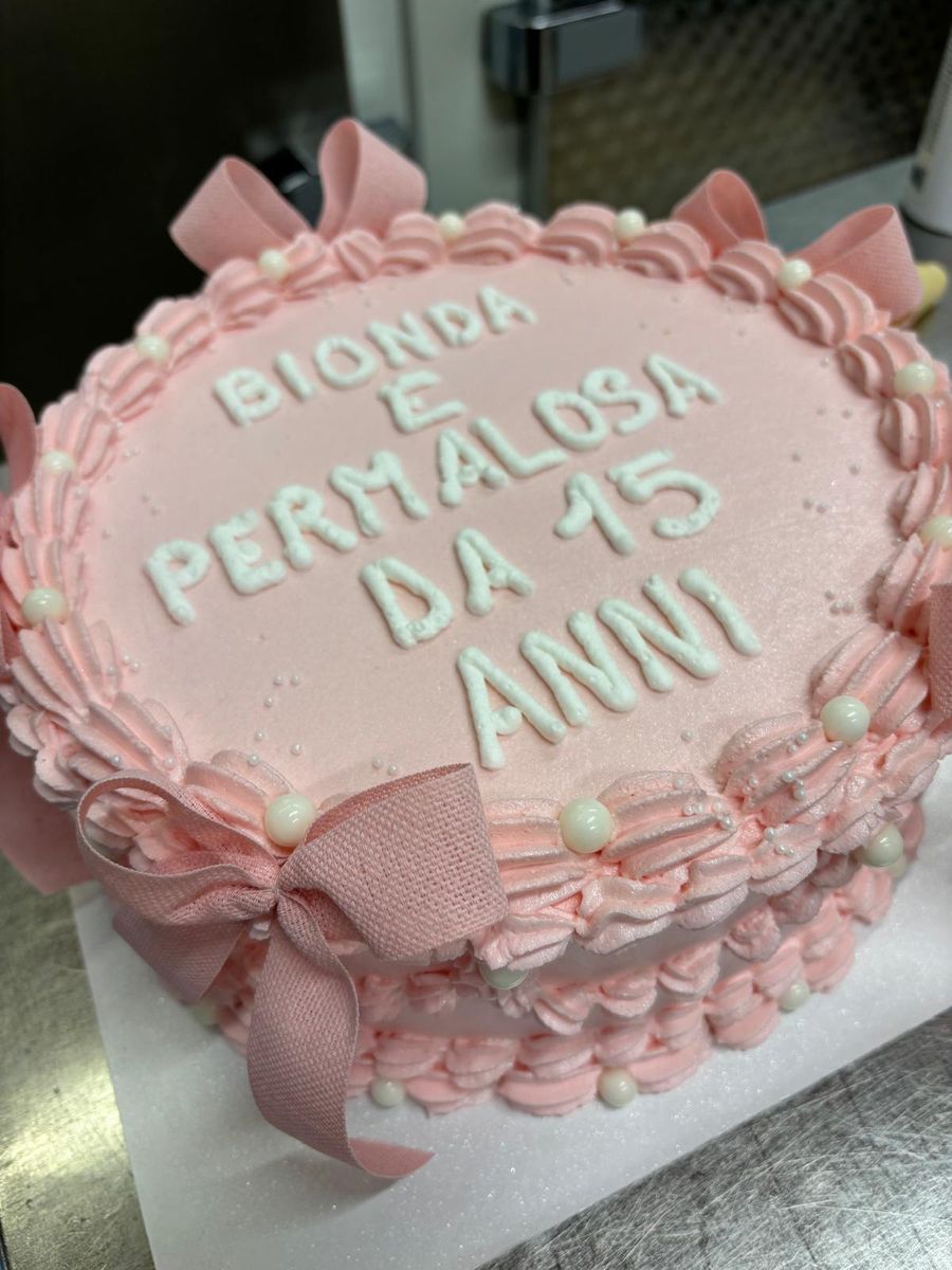 Torta rosa con ciuffi di crema e dedica per i quindici anni