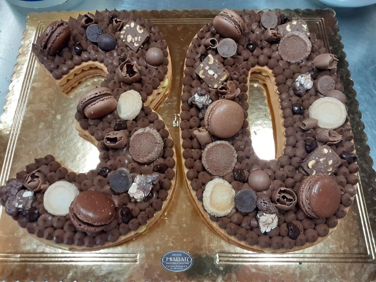 Cream tart a forma di 30 al cioccolato con macaron e praline