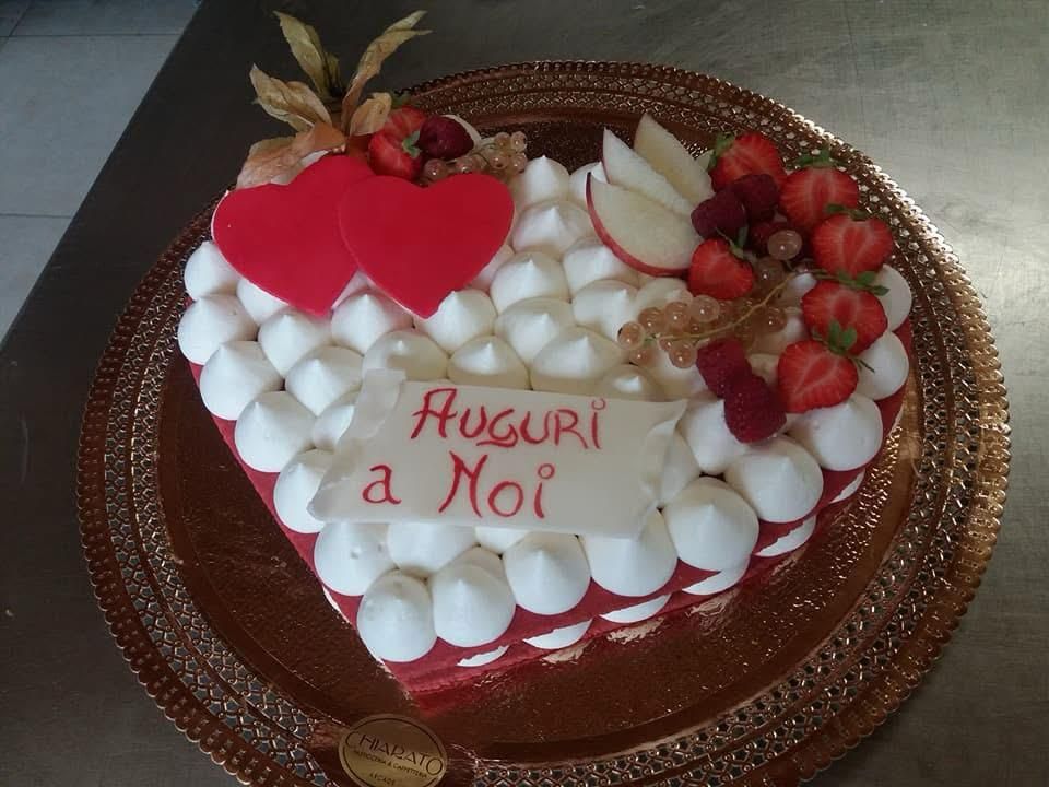 Cream tart a cuore con ciuffi di crema, fragole e dedica