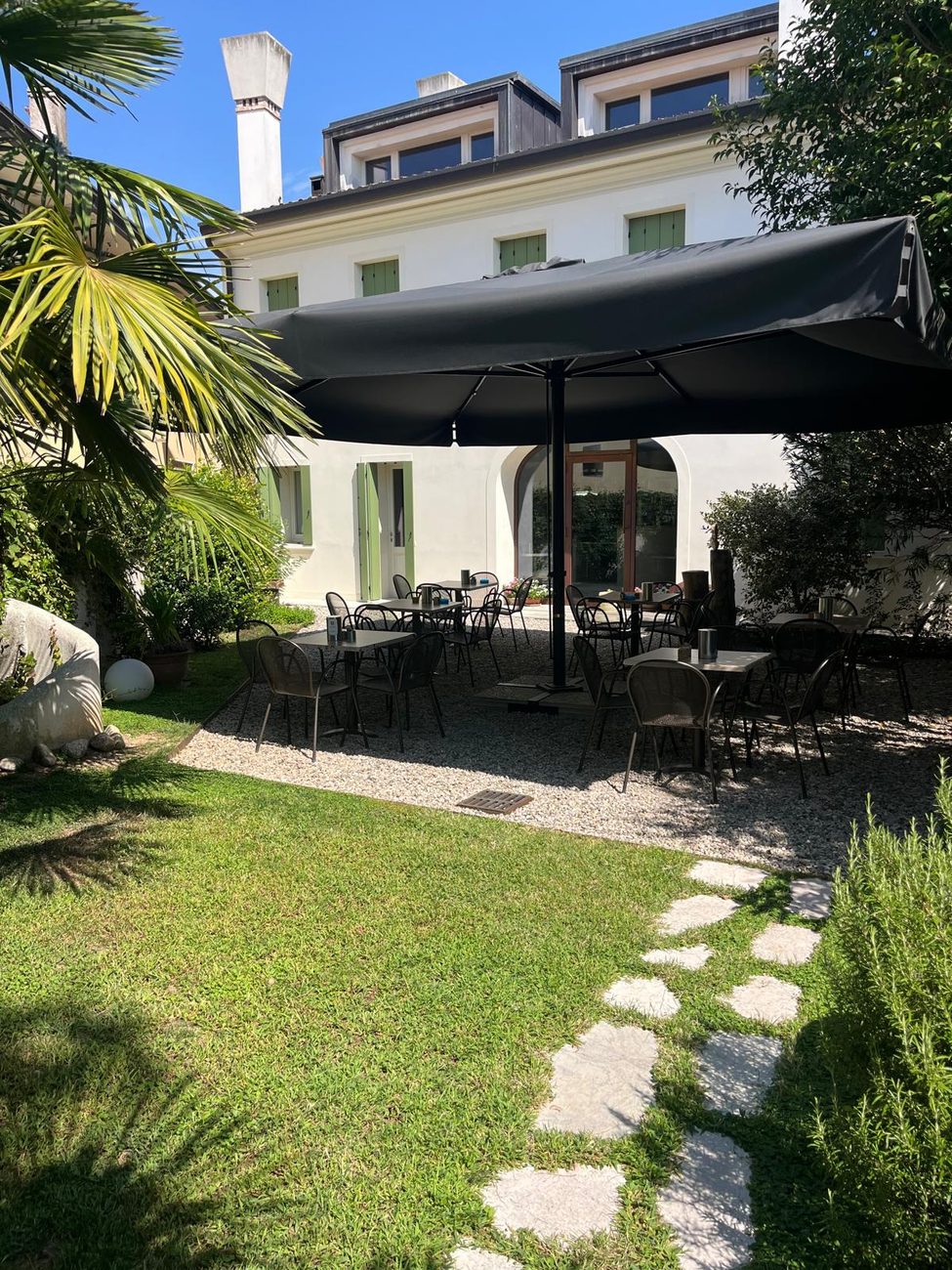 Il giardino della pasticceria con i tavolini all'ombra dell'ombrellone