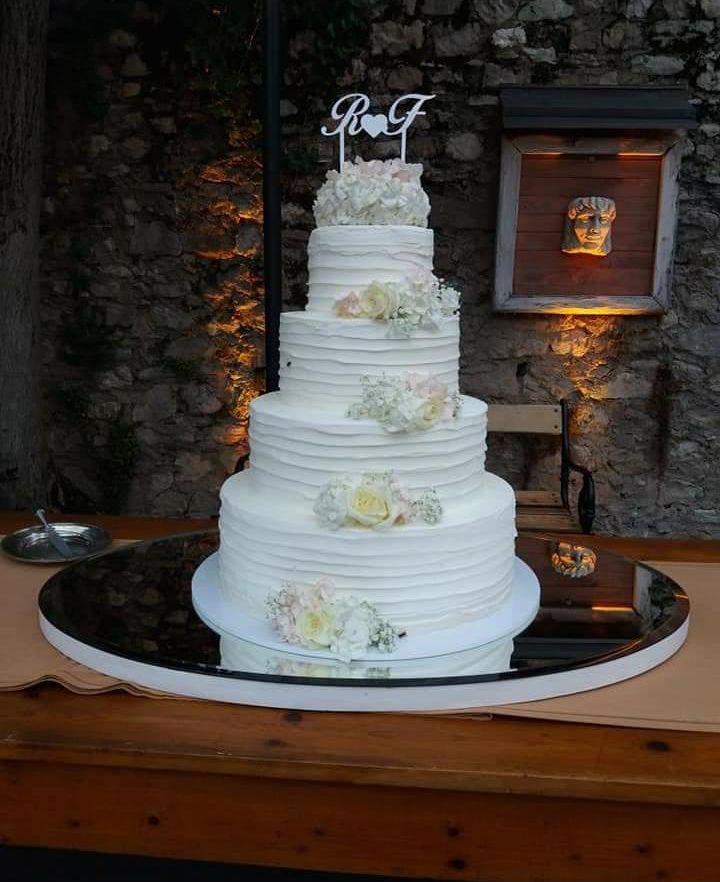 Torta nuziale a cinque piani allestita in sala per il taglio