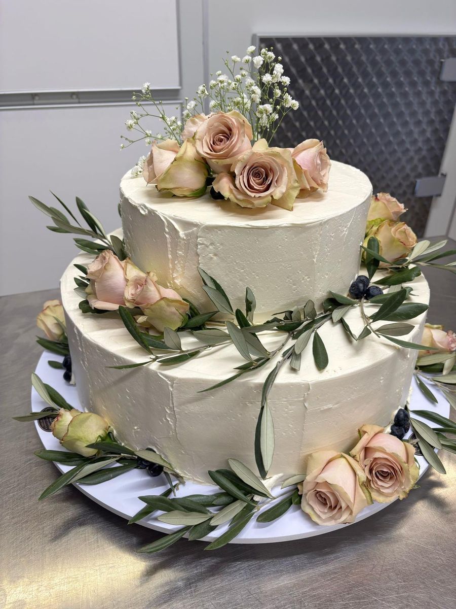 Torta nuziale a due piani con rose cipria e rami d'ulivo