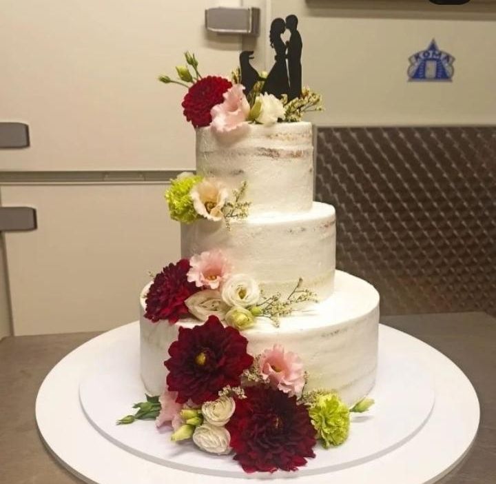 Torta nuziale a tre piani con dalie rosse e fiori bianchi