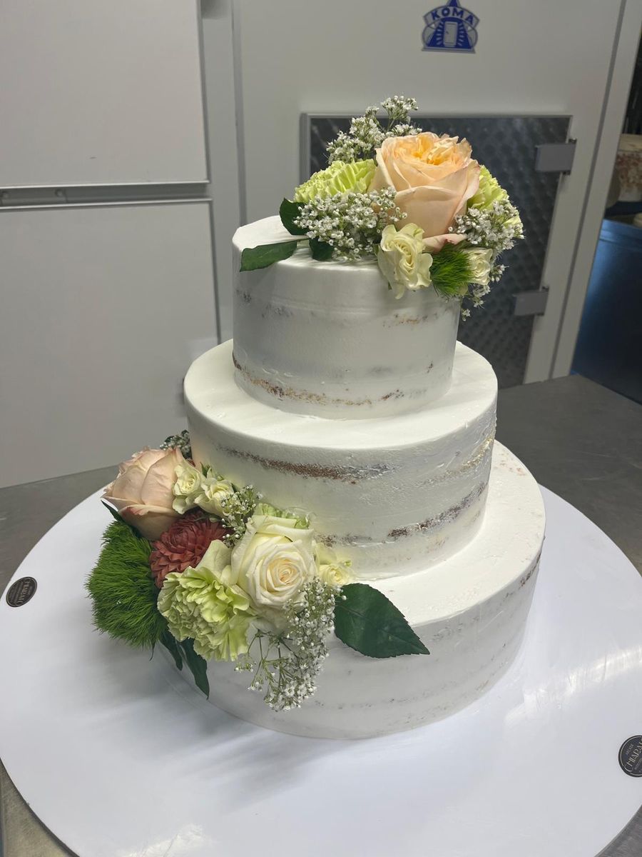 Torta nuziale a due piani con rose color pesca e fiori verdi