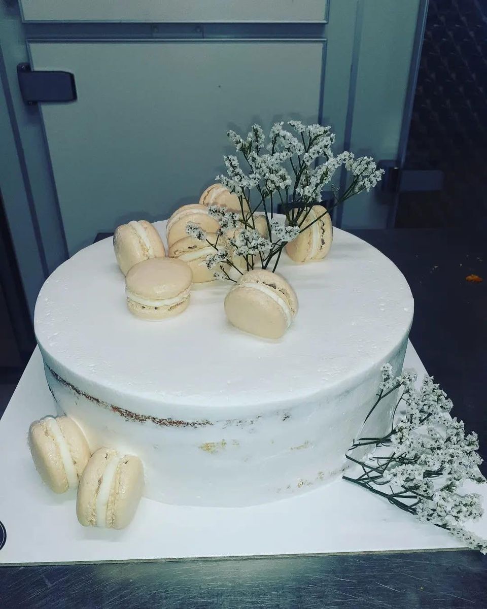 Torta nuziale a un piano con macaron e velo da sposa
