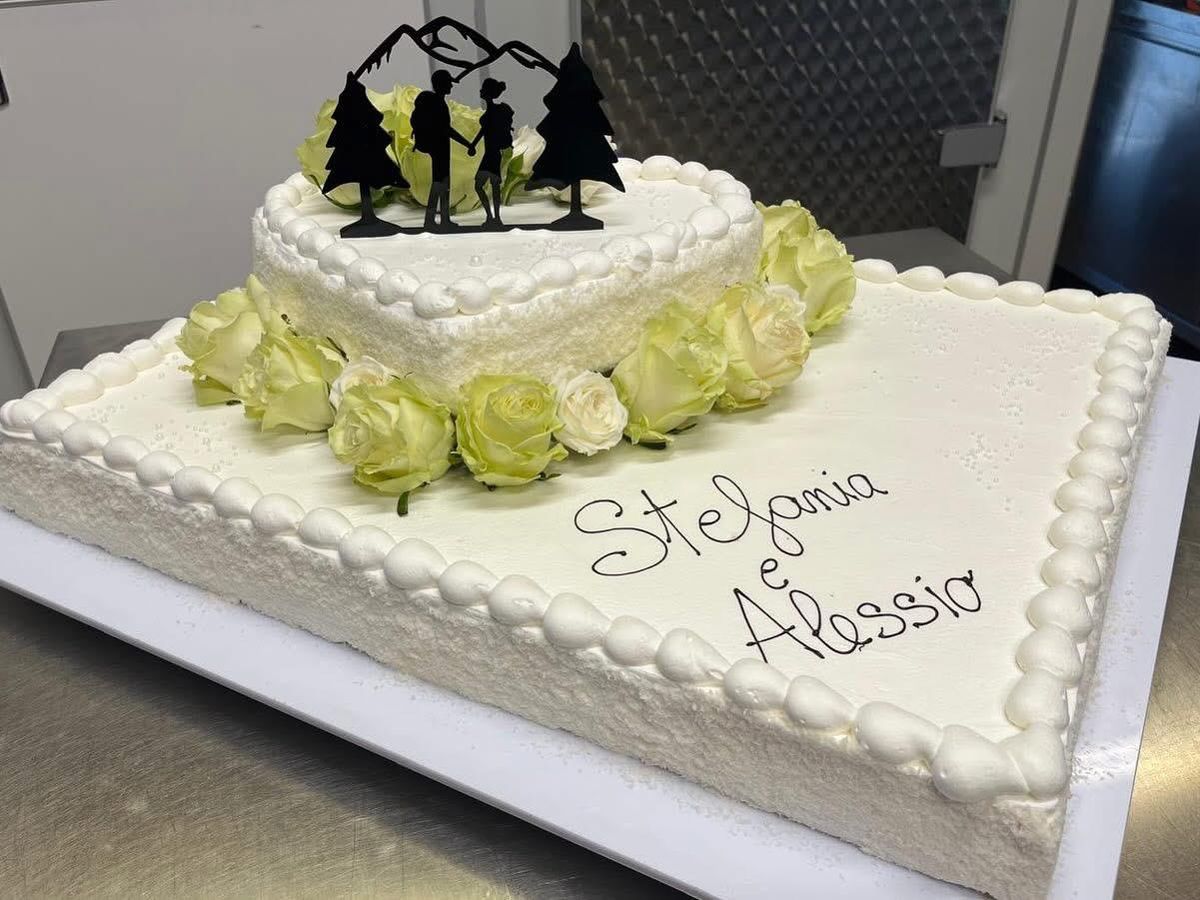 Torta nuziale rettangolare con rose bianche e verdi e i nomi degli sposi