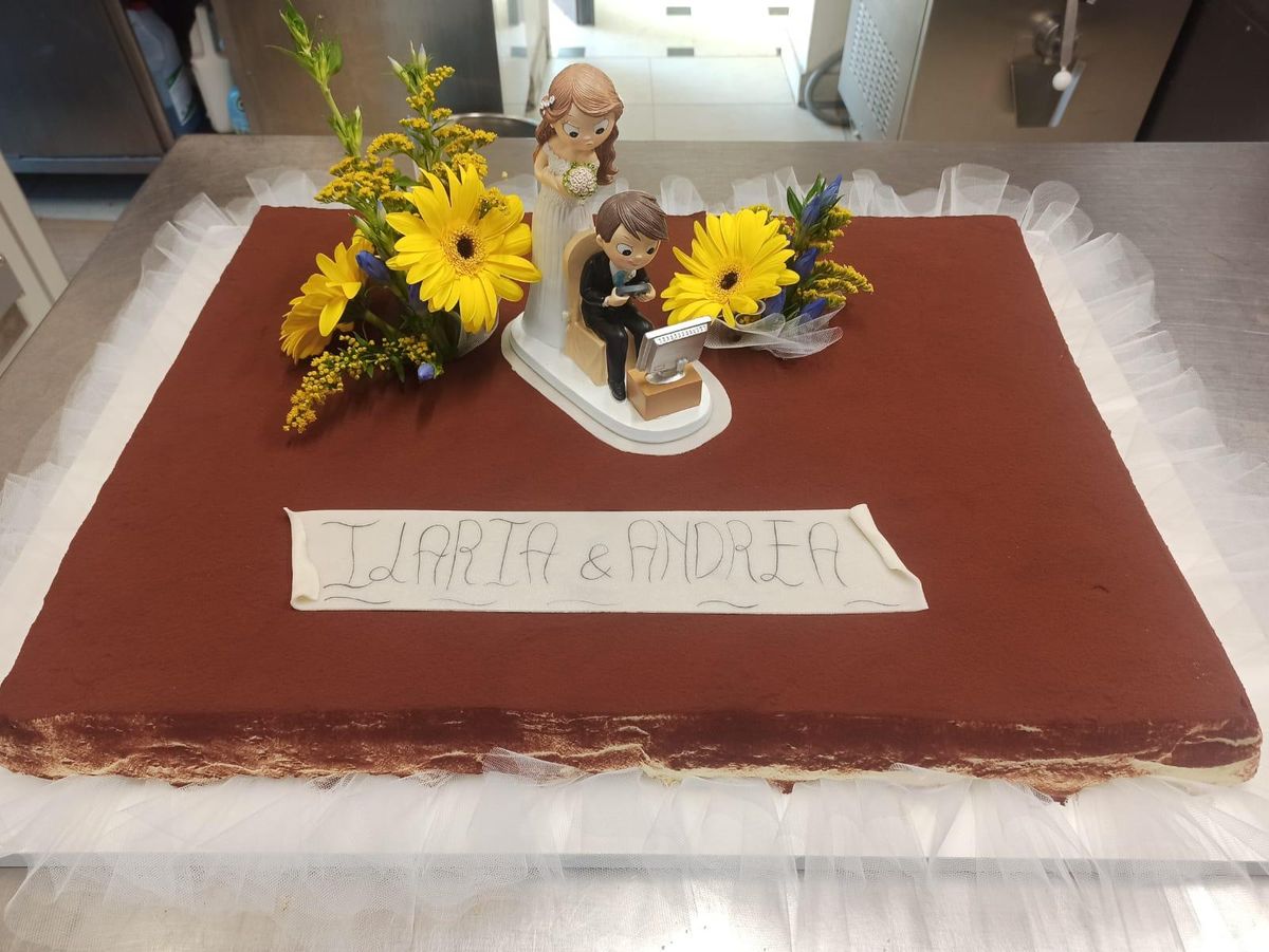 Torta nuziale rettangolare al cioccolato con girasoli e statuine degli sposi