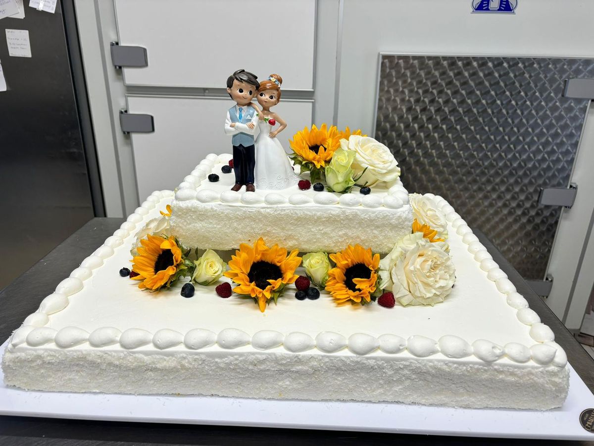 Torta nuziale rettangolare con girasoli e statuine degli sposi
